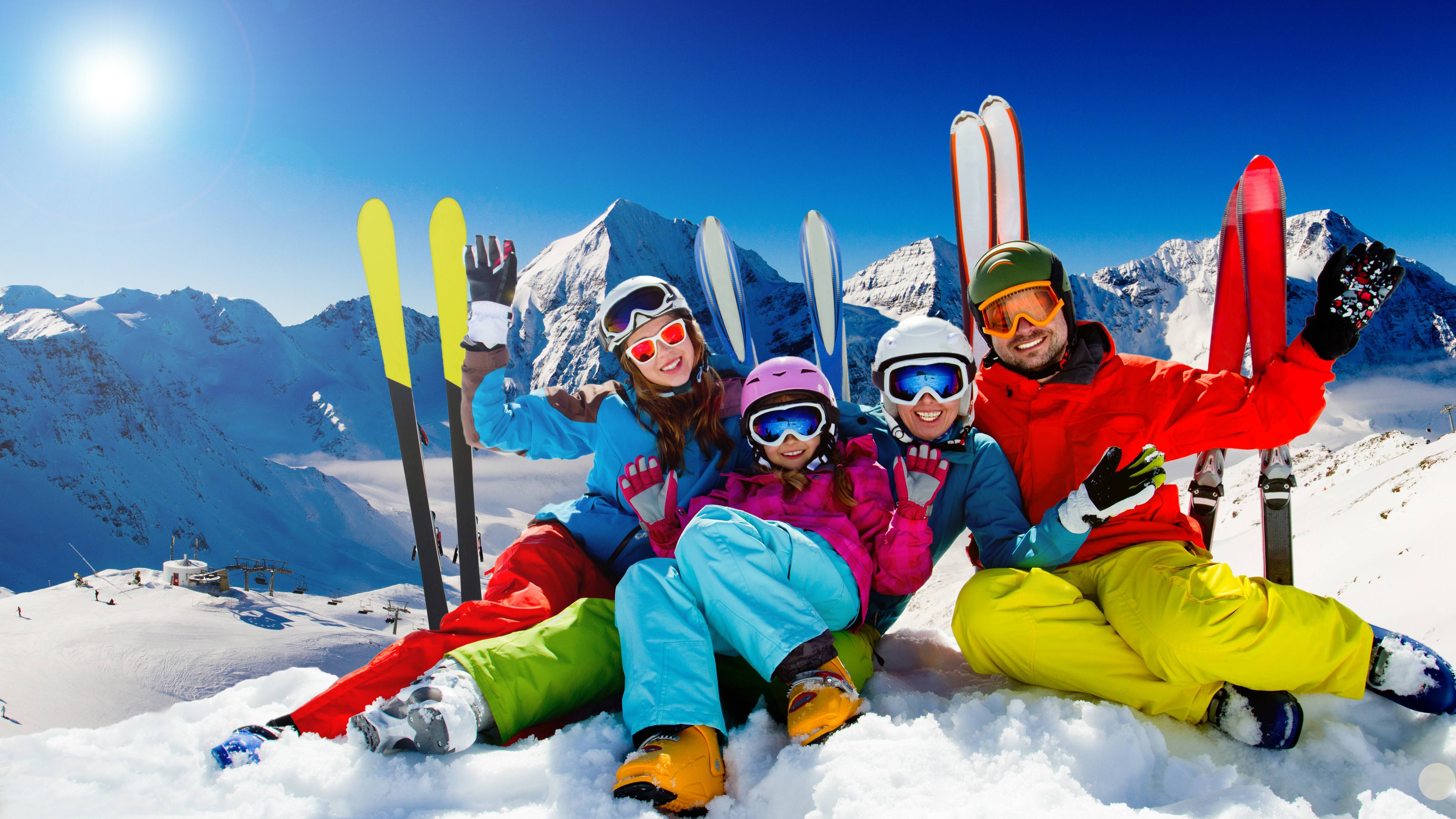 Виды отдыха на каникулах. Семья на горных лыжах. Горнолыжный спорт. Семья катается на лыжах в горах. Зимний курорт.